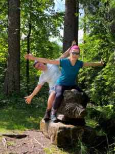 2 Menschen sitzend auf einem Holzkeiler