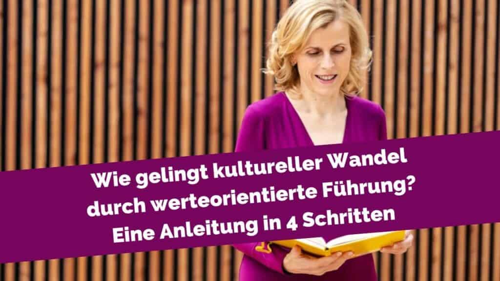 Frau vor Holzwand mit Buch in der Hand