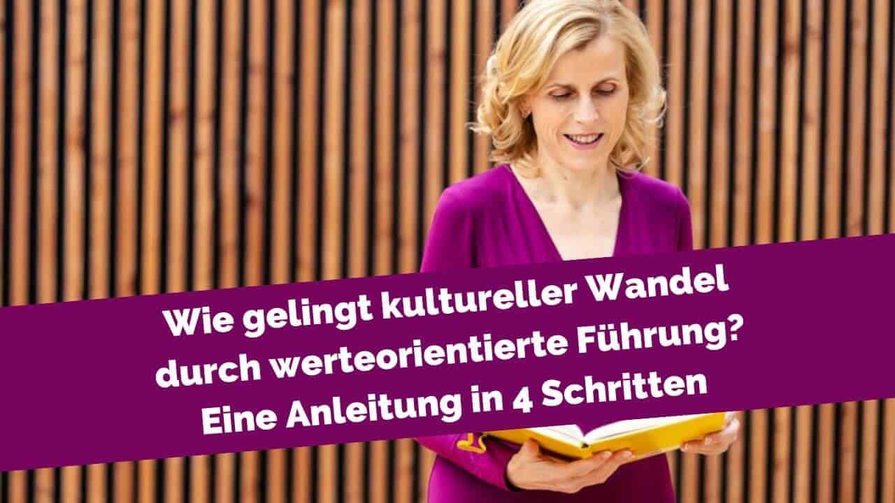 Frau vor Holzwand mit Buch in der Hand
